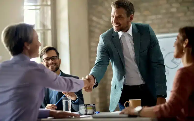 business-coworkers-shaking-hands-meeting-office-focus-is-businessman-scaled-1.webp
